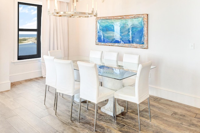 dining space with baseboards and wood finished floors