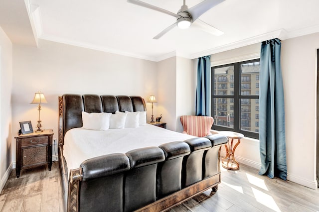 bedroom with light wood-style floors, baseboards, crown molding, and ceiling fan
