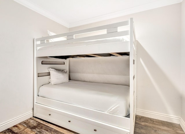 unfurnished bedroom featuring ornamental molding, wood finished floors, and baseboards