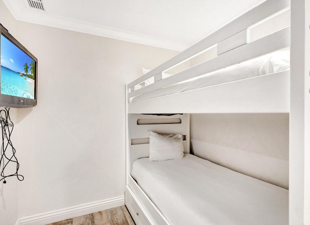 unfurnished bedroom featuring ornamental molding, wood finished floors, and baseboards