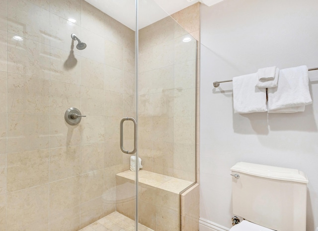 full bath featuring a stall shower and toilet