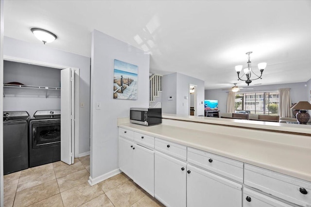 25 Misty Cv Unit 118, Miramar Beach, FL 32550 - kitchen with washer and clothes dryer, stainless steel microwave, a chandelier, white cabinets, and hanging light fixtures