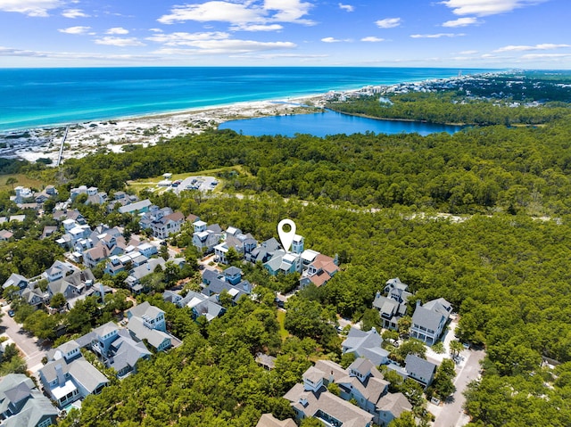 aerial view of residential area with a nearby body of water and a forest