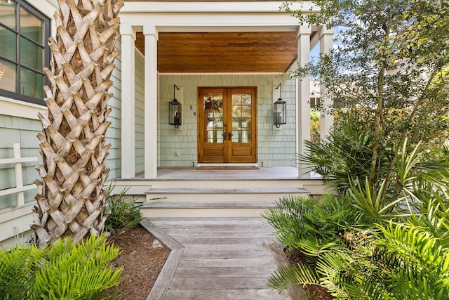view of exterior entry featuring french doors and a porch
