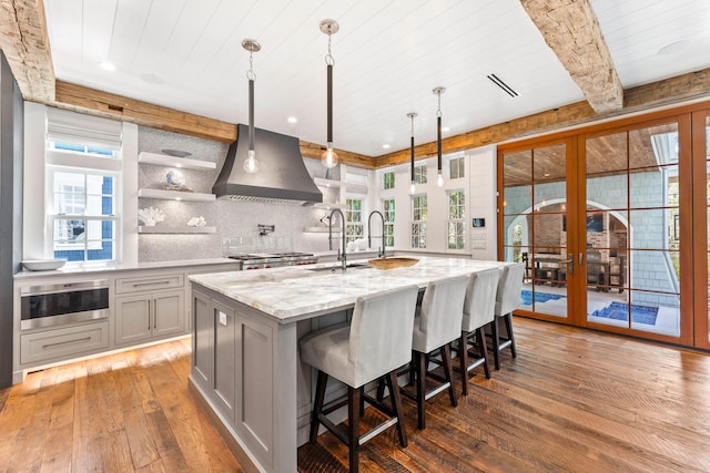 kitchen featuring hardwood / wood-style floors, custom range hood, gray cabinetry, wooden ceiling, and light stone countertops