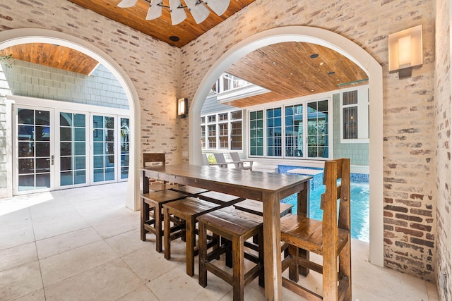 dining space with wood ceiling, a ceiling fan, tile patterned floors, and plenty of natural light