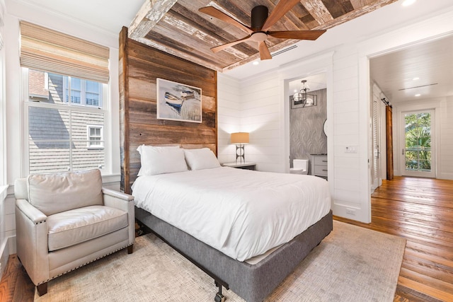 bedroom with multiple windows, hardwood / wood-style flooring, ornamental molding, wood walls, and recessed lighting