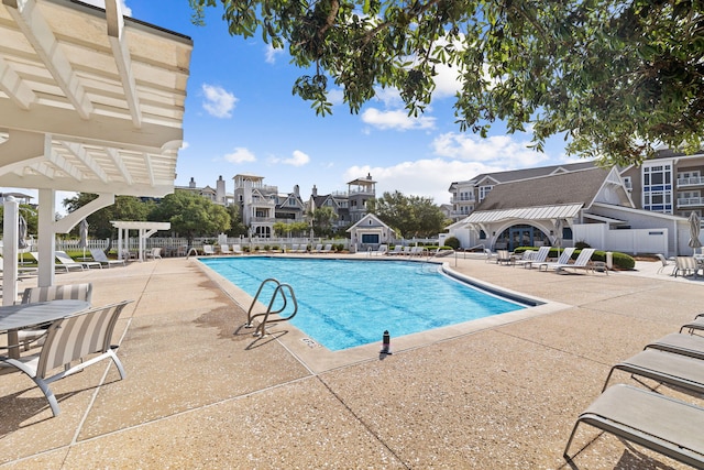 community pool featuring a patio area, fence, and a pergola