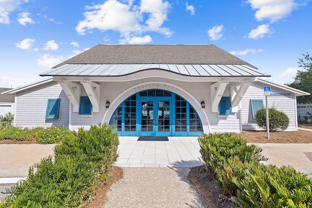 rear view of house with a standing seam roof, french doors, and metal roof