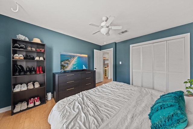 bedroom with wood finished floors, a closet, ceiling fan, and baseboards
