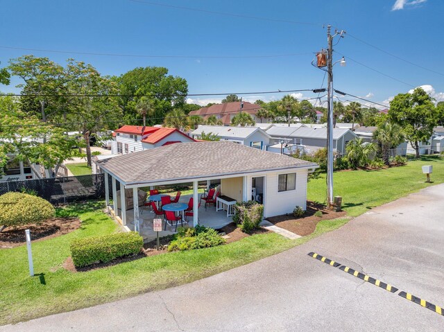 view of front of home with roof with shingles, a patio, and a residential view