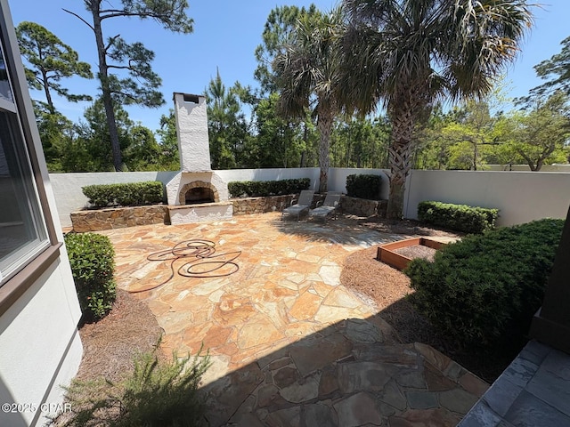 5303 Hopetown Ln, Panama City Beach, FL 32408 - view of patio with an outdoor stone fireplace and fence