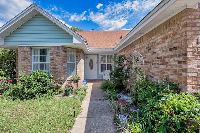102 Wright Dr, Niceville, FL 32578 - view of exterior entry featuring brick siding and a shingled roof