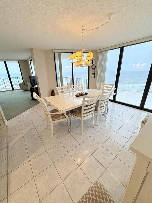 11347 Front Beach Rd # 601, Panama City Beach, FL 32407 - dining room featuring light tile patterned flooring, a textured ceiling, a chandelier, and light carpet
