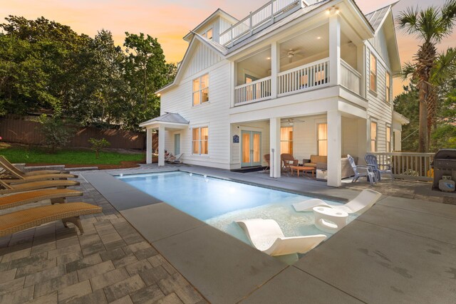 241 Overlook Dr, Miramar Beach, FL 32550 - back of house at dusk featuring a balcony, ceiling fan, french doors, fence, and board and batten siding