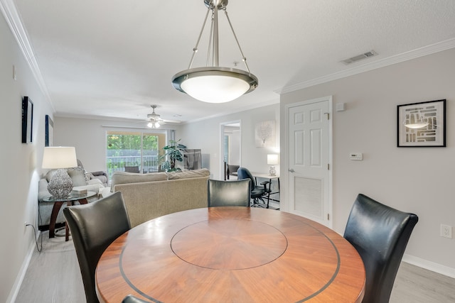4274 Calinda Ln Unit 225, Niceville, FL 32578 - dining area with crown molding, baseboards, light wood-style flooring, and a ceiling fan