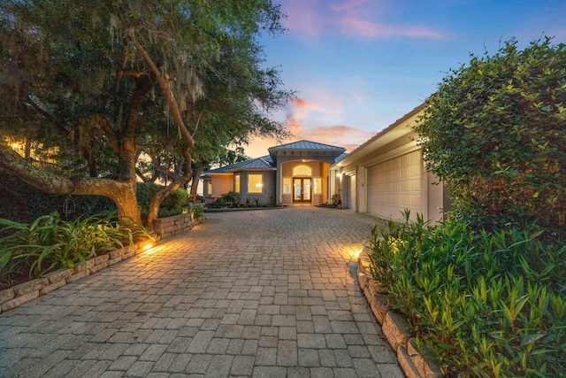 411 Calhoun Ave, Destin, FL 32541 - mediterranean / spanish home with a garage, decorative driveway, a standing seam roof, metal roof, and french doors