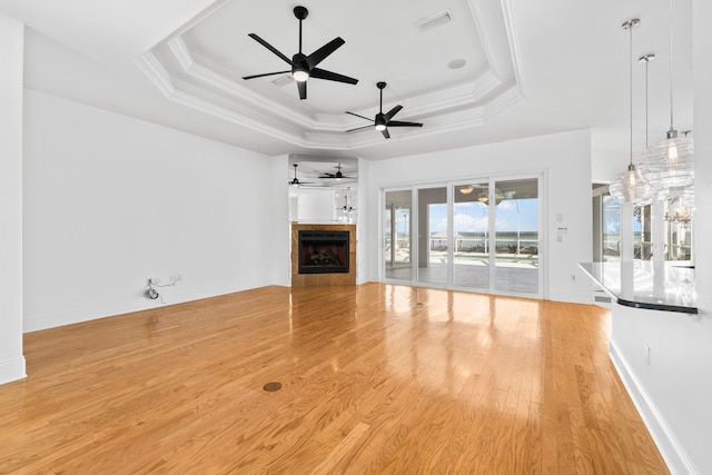 411 Calhoun Ave, Destin, FL 32541 - unfurnished living room featuring ceiling fan, a tray ceiling, wood finished floors, a fireplace, and baseboards