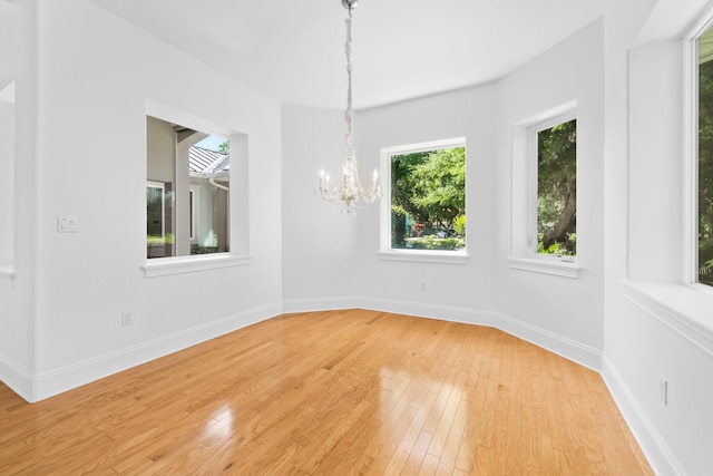 411 Calhoun Ave, Destin, FL 32541 - unfurnished room featuring healthy amount of natural light, light wood finished floors, a chandelier, and baseboards