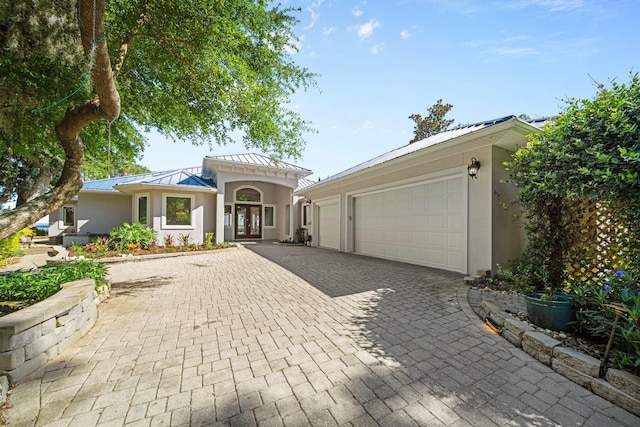 411 Calhoun Ave, Destin, FL 32541 - mediterranean / spanish home with a standing seam roof, decorative driveway, stucco siding, and french doors