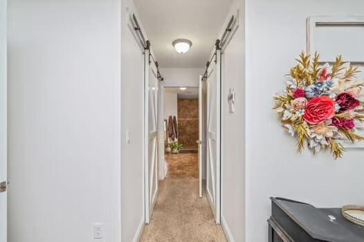 5930 Wind Trace Rd, Crestview, FL 32536 - hallway with a barn door and light carpet