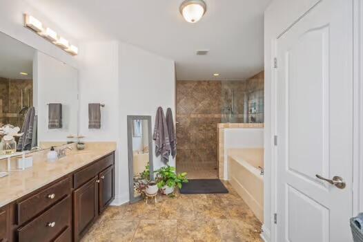 5930 Wind Trace Rd, Crestview, FL 32536 - bathroom featuring tiled shower, a bath, and vanity