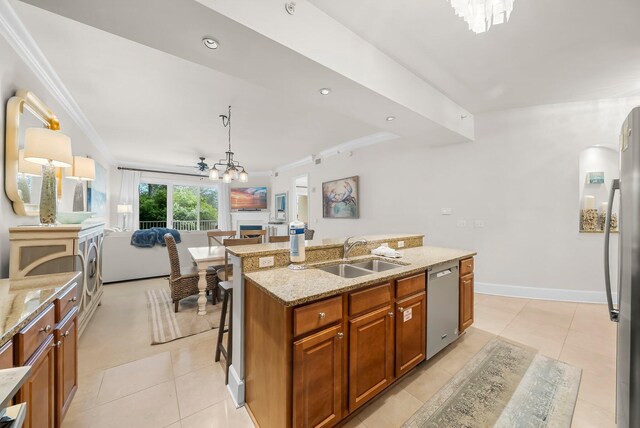 1653 W County Highway 30a Unit 1109, Santa Rosa Beach, FL 32459 - kitchen featuring a sink, appliances with stainless steel finishes, open floor plan, brown cabinetry, and crown molding