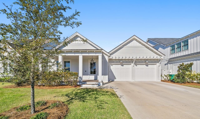 view of front of home with board and batten siding, a garage, a front lawn, and driveway