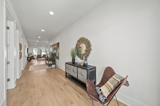 corridor featuring recessed lighting, light wood-style flooring, and baseboards
