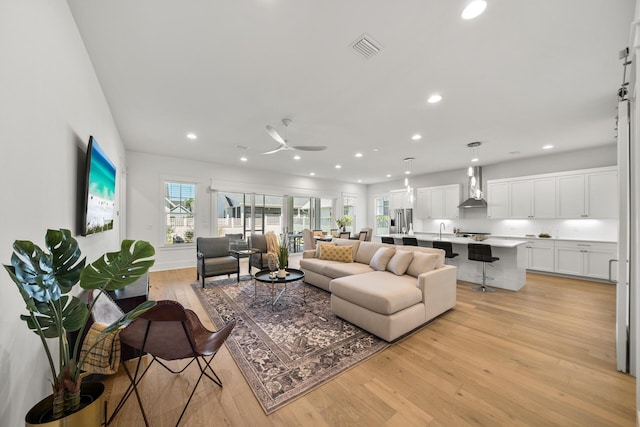 living room featuring light wood-style flooring, recessed lighting, and ceiling fan