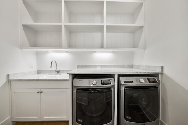clothes washing area featuring separate washer and dryer and wood finished floors