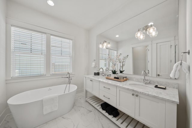 bathroom featuring marble finish flooring, double vanity, a freestanding bath, baseboards, and recessed lighting
