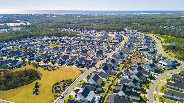 view of property location featuring a forest and nearby suburban area