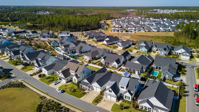 aerial view of property's location featuring nearby suburban area and a heavily wooded area