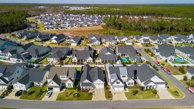 aerial view of property and surrounding area with a forest and nearby suburban area