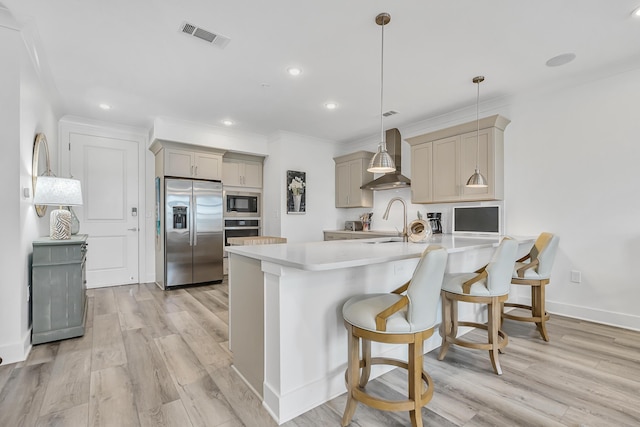 179 S County Highway 393 Unit 445, Santa Rosa Beach, FL 32459 - kitchen featuring built in appliances, wall chimney exhaust hood, a peninsula, a breakfast bar, and light countertops