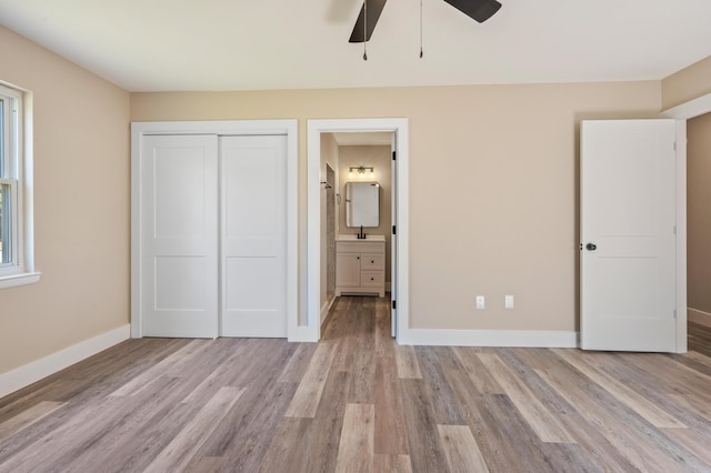 1411 28th St, Niceville, FL 32578 - unfurnished bedroom featuring light wood-type flooring, a closet, baseboards, connected bathroom, and a sink