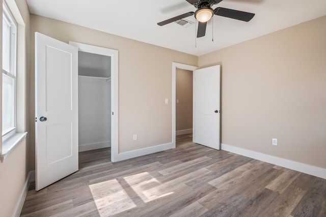 1411 28th St, Niceville, FL 32578 - unfurnished bedroom with wood finished floors, baseboards, a closet, and a ceiling fan