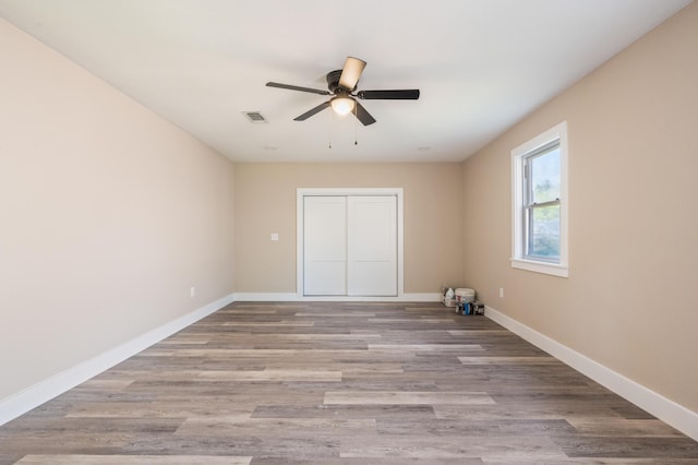 1411 28th St, Niceville, FL 32578 - unfurnished bedroom with wood finished floors, baseboards, and ceiling fan