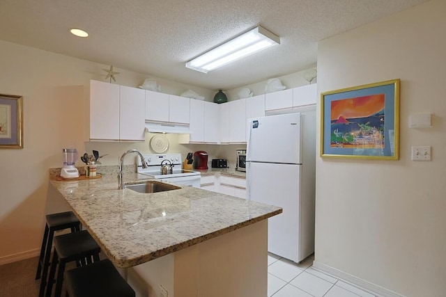 2606 Scenic Gulf Dr Unit 4108, Miramar Beach, FL 32550 - kitchen featuring white appliances, under cabinet range hood, a peninsula, a kitchen breakfast bar, and light stone counters