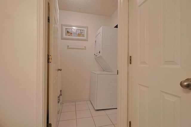 2606 Scenic Gulf Dr Unit 4108, Miramar Beach, FL 32550 - washroom featuring estacked washer and dryer, light tile patterned floors, and a textured ceiling