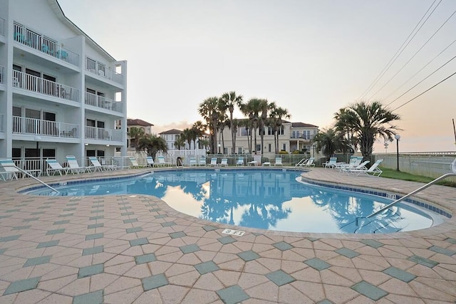 2606 Scenic Gulf Dr Unit 4108, Miramar Beach, FL 32550 - pool at dusk featuring a community pool, a patio area, and fence