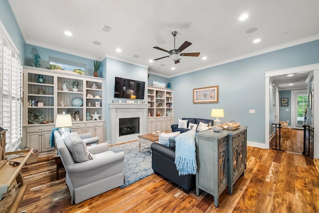 728 Breakers St, Watersound, FL 32461 - living room with ceiling fan, wood finished floors, a fireplace, recessed lighting, and ornamental molding