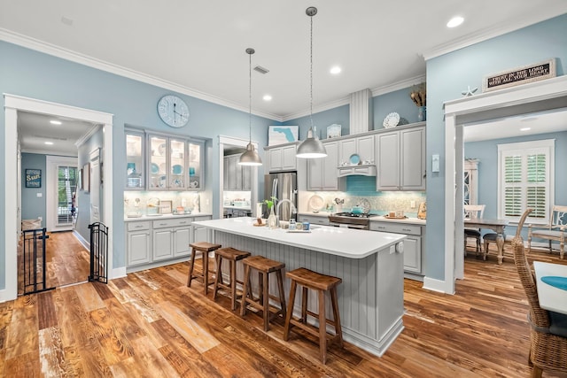 728 Breakers St, Watersound, FL 32461 - kitchen featuring stainless steel appliances, a kitchen bar, crown molding, a kitchen island with sink, and tasteful backsplash