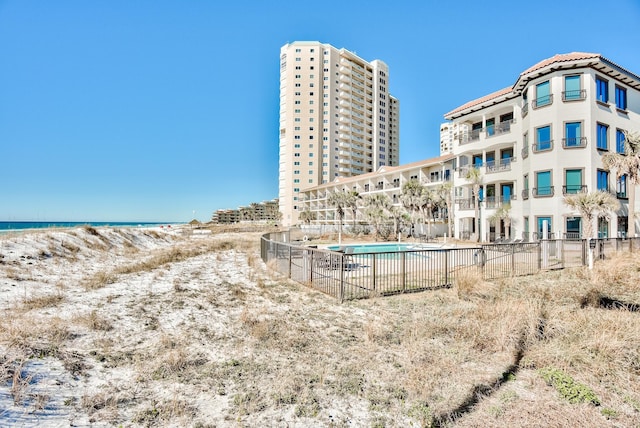 134 Norwood Dr Ph 3, Miramar Beach, FL 32550 - view of building exterior featuring fence, view of water and beach, and a community pool