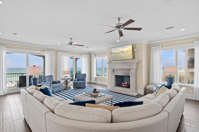 134 Norwood Dr Ph 3, Miramar Beach, FL 32550 - living room featuring crown molding, healthy amount of natural light, a lit fireplace, a ceiling fan, and recessed lighting