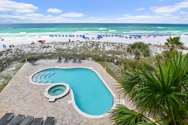 134 Norwood Dr Ph 3, Miramar Beach, FL 32550 - view of swimming pool with fence, view of water and beach, a patio area, and a pool with connected hot tub