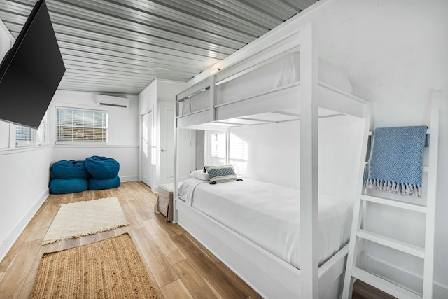 216 E Park Place Ave, Inlet Beach, FL 32461 - bedroom with a wall unit AC, wood finished floors, and baseboards