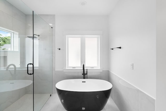 180 Rearden Way, Santa Rosa Beach, FL 32459 - full bath with a freestanding tub, a shower stall, tile walls, tile patterned floors, and a wainscoted wall