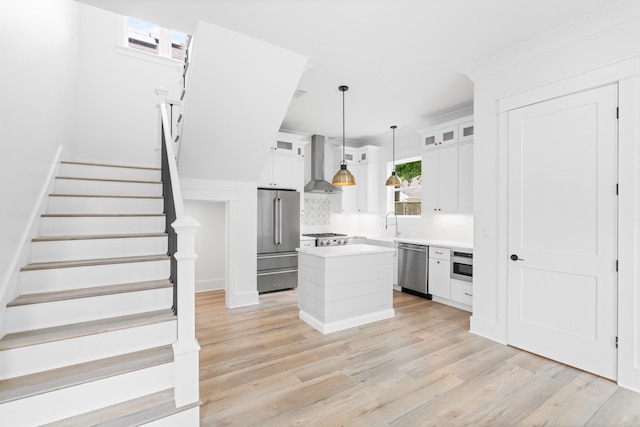 180 Rearden Way, Santa Rosa Beach, FL 32459 - kitchen featuring stainless steel appliances, wall chimney range hood, white cabinets, backsplash, and a kitchen island